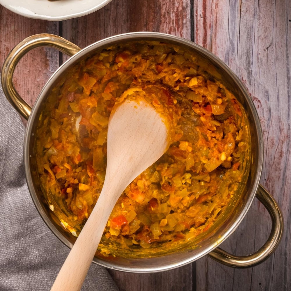 Tomatoes and spices added to the cooked vegetables.