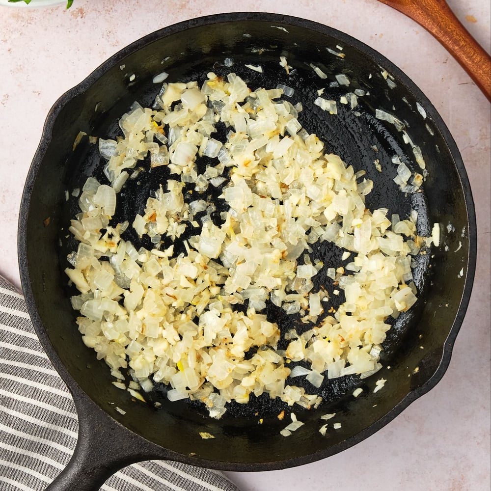 Onion and garlic cooked in a cast-iron pan.