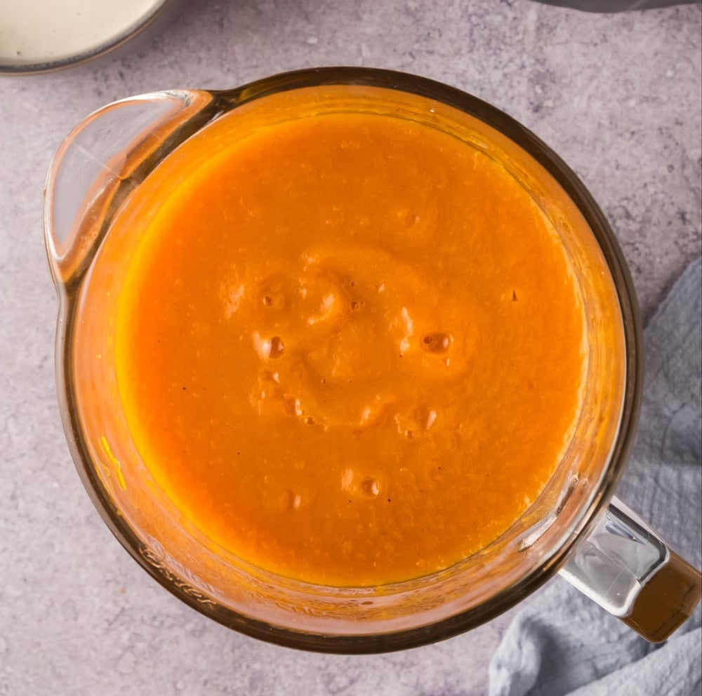 Broth and vegetables blended in a blender jar.