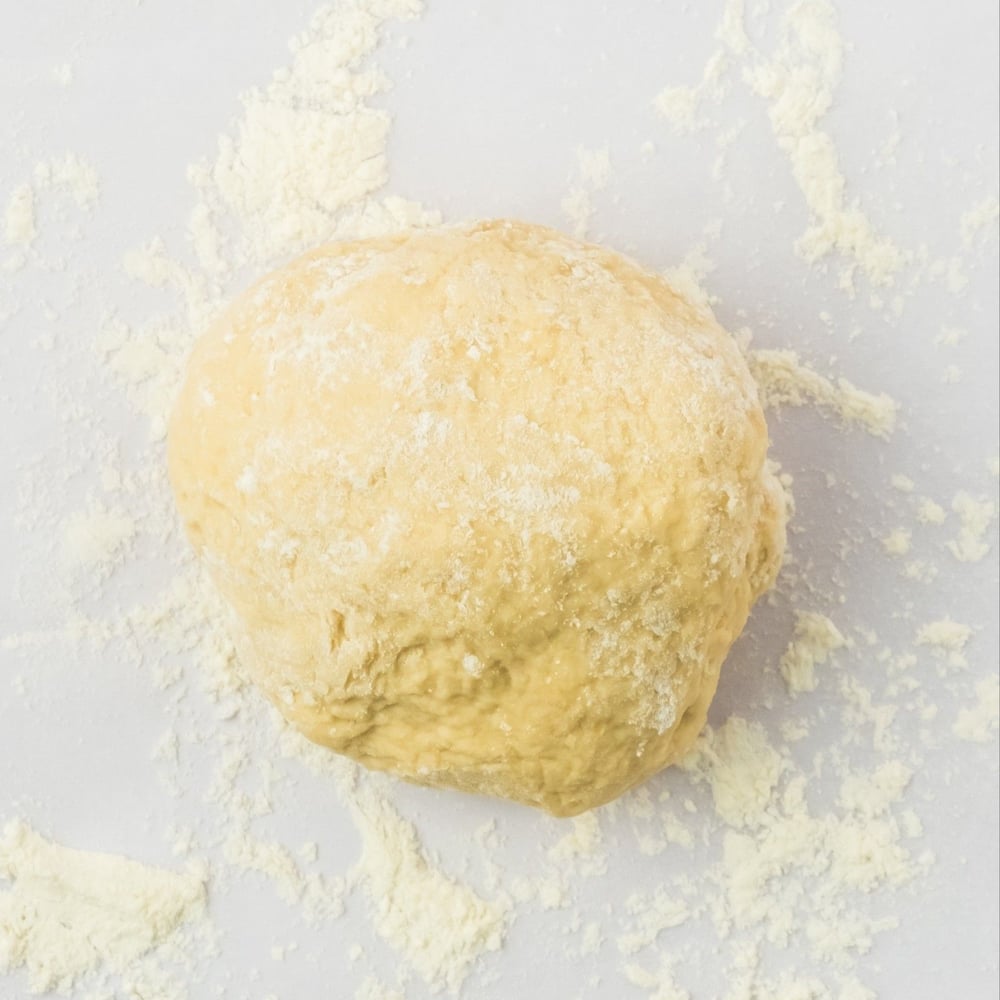 Vegan cannoli dough on parchment, after being kneaded
