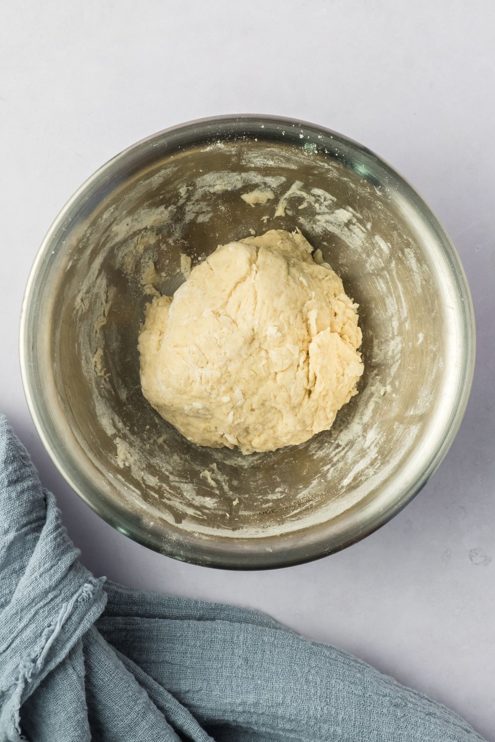Vegan cannoli shell dough, just formed, in a mixing bowl.