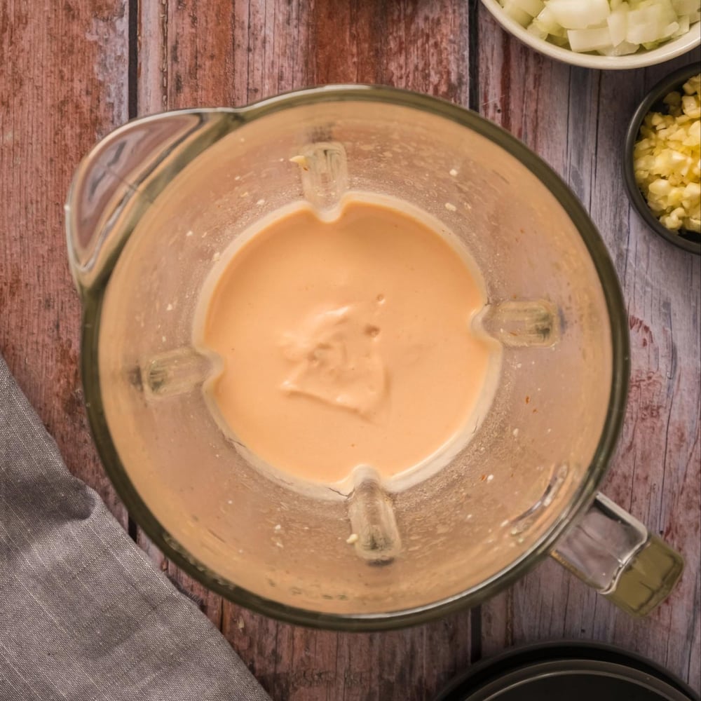 Cashew sauce blended with tomato paste in a blender.